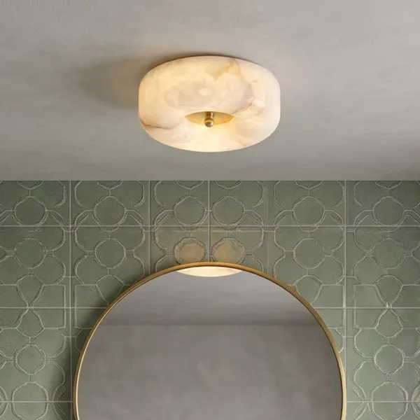 Alabaster pebble ceiling light above a round bathroom mirror