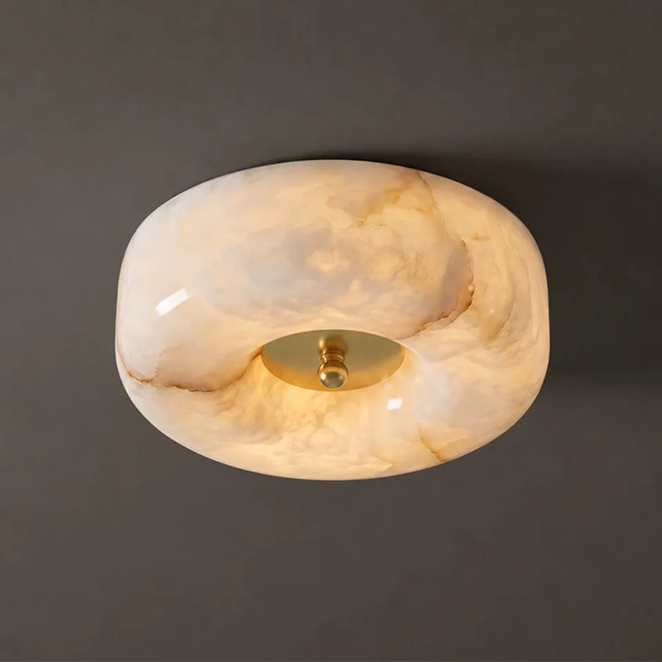 Pebble ceiling light in natural alabaster glowing warm on a dark ceiling