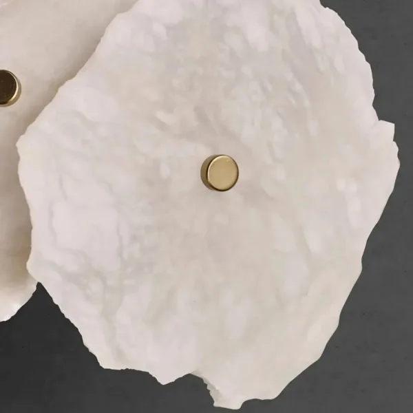 White raw-edged alabaster slab with brass cap, close-up