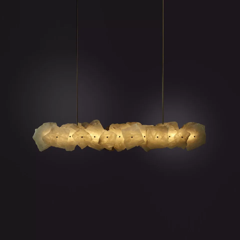 Home 4 Brass linear chandelier with raw-edged alabaster slabs, lit against a dark wall