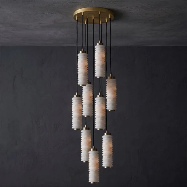Ribbed alabaster chandelier with nine glowing cylinders on a round brass canopy, dark wall