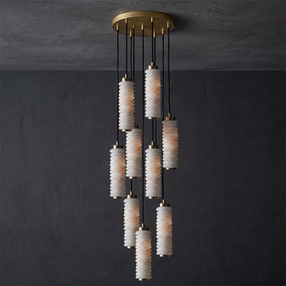 Home 5 Ribbed alabaster chandelier with nine glowing cylinders on a round brass canopy, dark wall