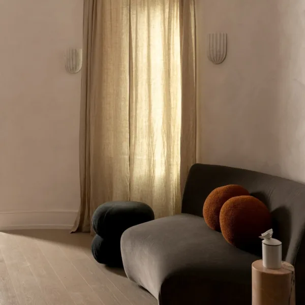 Pair of alabaster shell wall lights beside a linen curtain in a living room