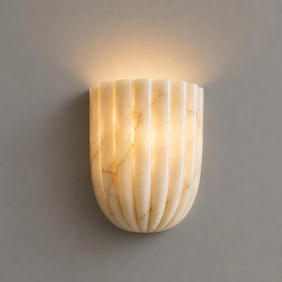 Home 4 Scallop wall light in natural alabaster glowing warm, light washing up a grey wall