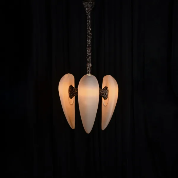 Front view of three glowing alabaster drops on the sculptural chandelier