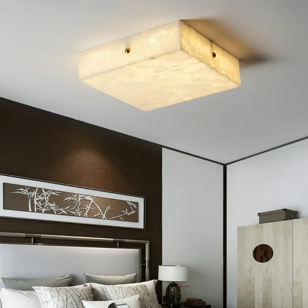 Square alabaster ceiling light above a bed in a modern bedroom