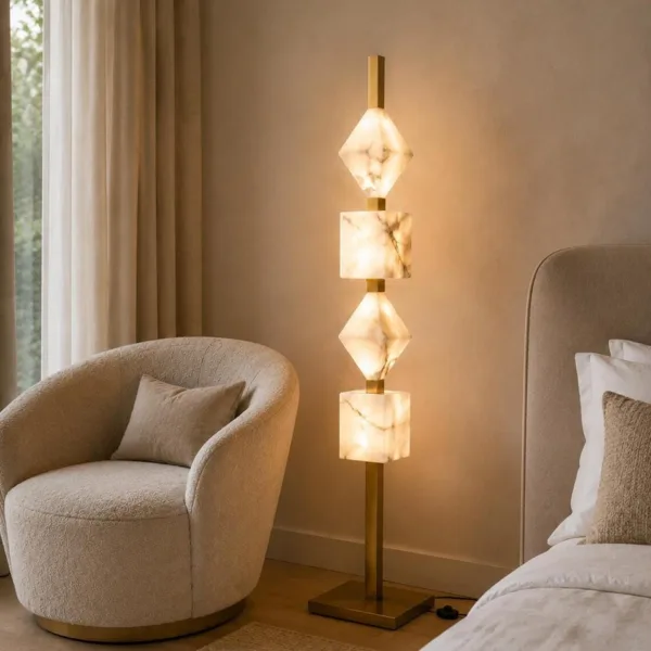 Stacked alabaster floor lamp in a bedroom beside a boucle chair and bed