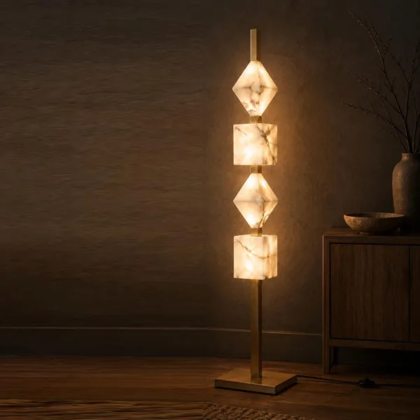 Alabaster column floor lamp lit in a dark room beside a wooden sideboard