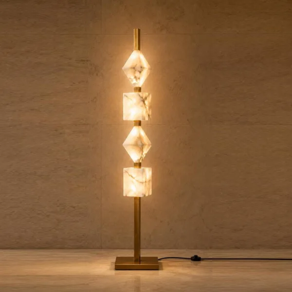 Lit stacked alabaster floor lamp against a stone wall