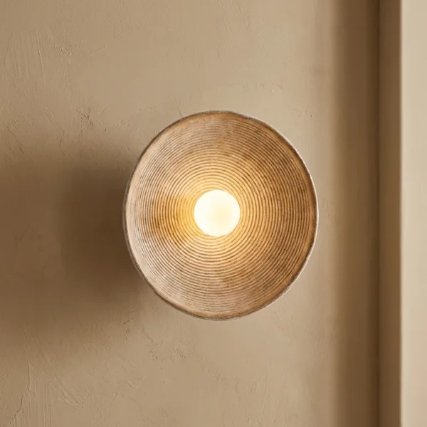 Front view of the teak wood wall light: concentric turned teak rings around a glowing opal borosilicate glass ball