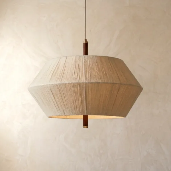 Thread-wound diamond pendant light glowing softly with a wood stem against a plaster wall