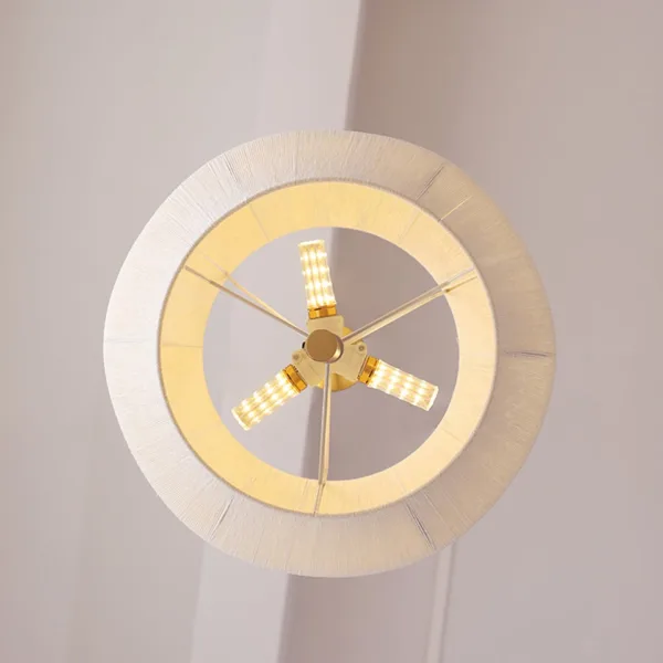 Underside view of the thread pendant light showing the white frame and the three lamp holders with LED lamps on a central brass hub