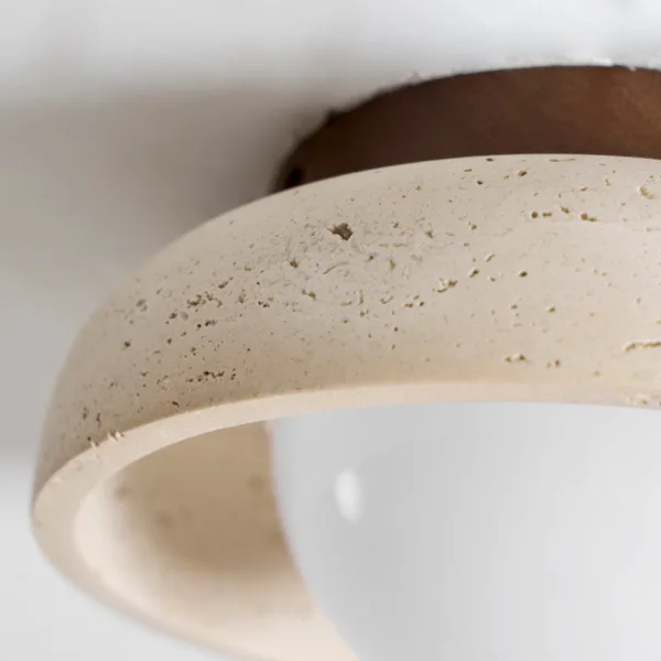 Natural pits on the honed rim of the travertine ceiling light