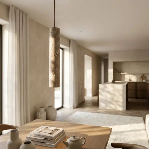 Travertine cylinder pendant light over a wooden dining table in an open-plan living and kitchen space