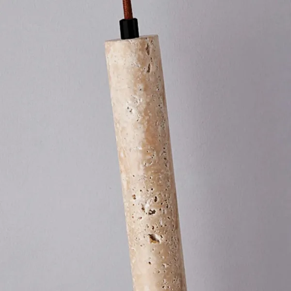 Top of the travertine cylinder pendant light showing the pitted stone and rust-brown fabric cord