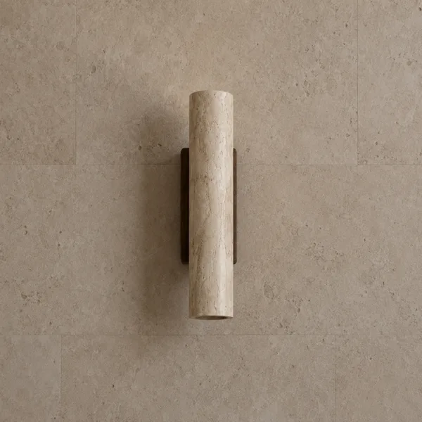 Travertine wall light unlit: a cream-beige stone cylinder on a dark wood backplate against stone tiles