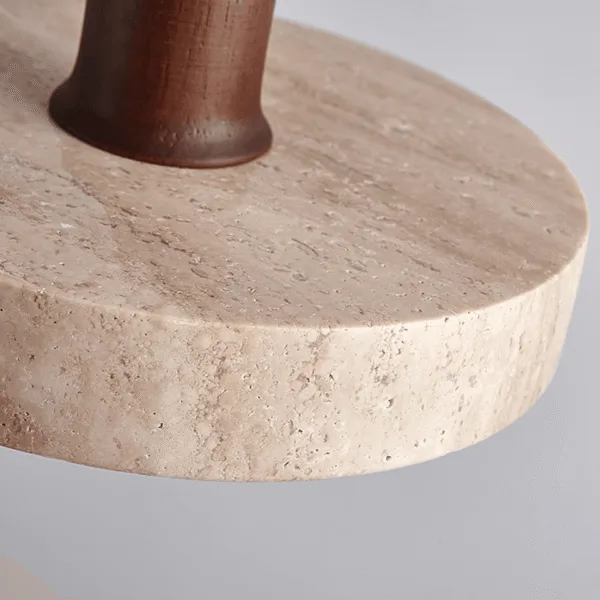 Close-up of the travertine disc pendant light showing the stone edge and wood cap