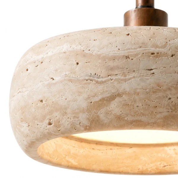Close-up of the real travertine drum shade, its bands and pits, glowing at the rim