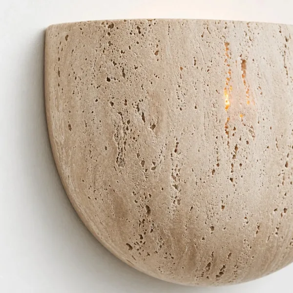 Close-up of the natural pits and banding in the honed travertine of the moon wall light