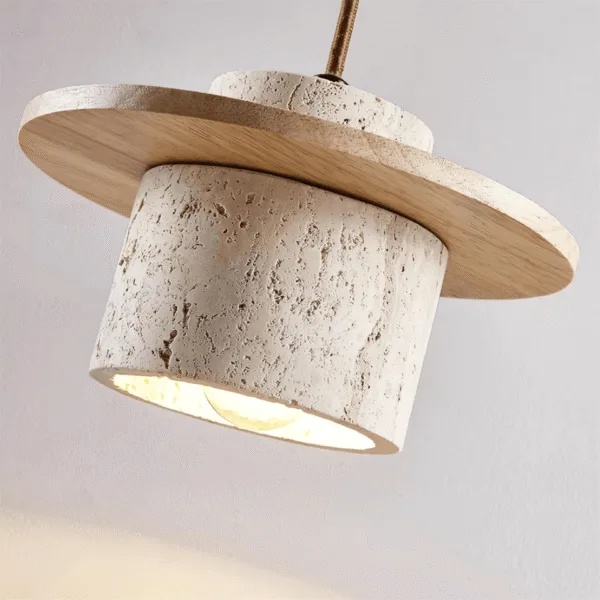 Underside of the travertine pendant light with an E27 bulb glowing inside the stone cylinder below a light wood disc