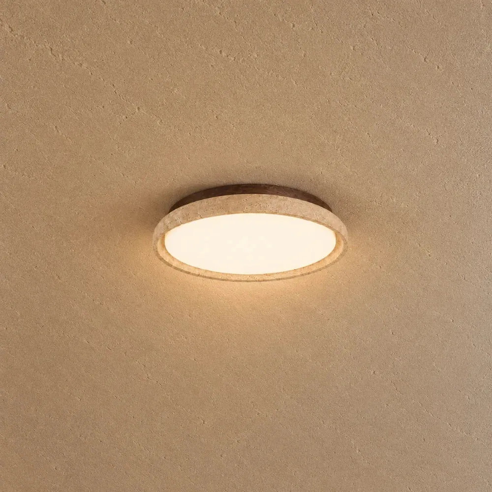 Travertine ceiling light for dining room: a slim stone ring glowing warm on a sand-coloured plaster ceiling