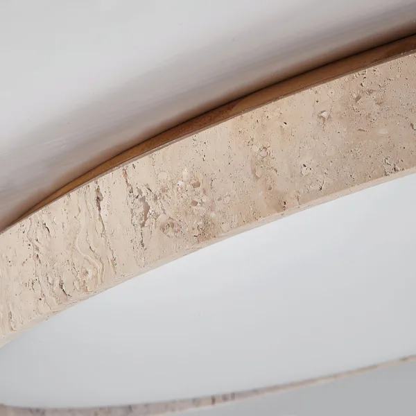 Close-up of honed travertine and the walnut-tone trim of the ceiling light