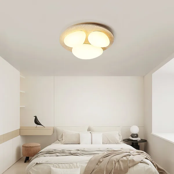 Bedroom ceiling light design: travertine pebble light above a bed