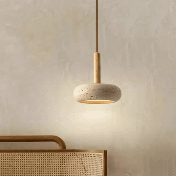 Travertine pebble pendant light glowing beside a cane-webbed headboard as a bedside light