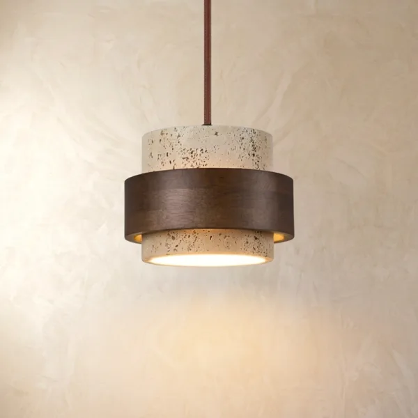 Travertine and wood pendant light glowing warm from its base against a cream plaster wall, dark wood band around the stone