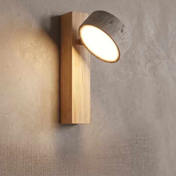 Close-up of the travertine wall mounted reading light for bedroom, its pivoting stone head turned out from the light oak bar
