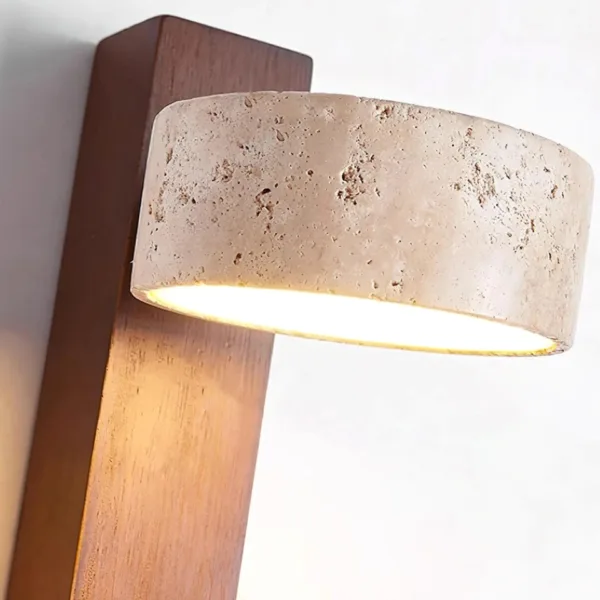 Close-up of the honed travertine head and LED diffuser on the walnut bar of the wall mounted reading light for bedroom
