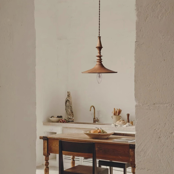 Turned wood pendant light above a rustic wooden kitchen table