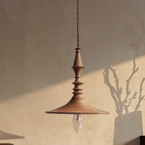 Turned wood pendant light casting a sculptural shadow on a limewash wall