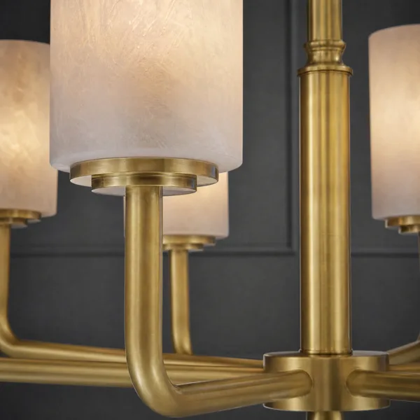 Close-up of brass arm and cup holding an alabaster cylinder